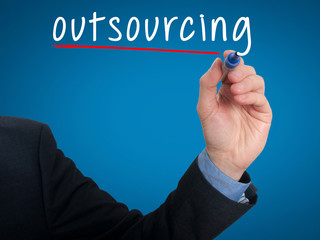 Businessman hand writing Outsourcing. Business concept.