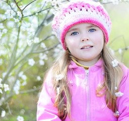 beautiful little girl near a flowering tree