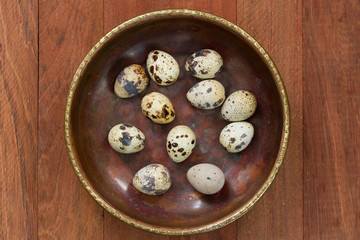 quail eggs on dish on brown background