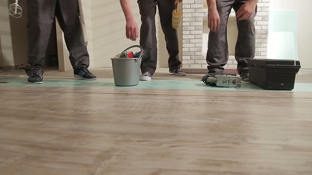 Legs of builders with  tools come to the object.