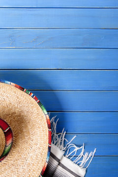 Mexican background with sombrero and traditional serape rug or blanket on old blue wood planked background Mexico fiesta cinco de mayo photo vertical