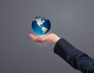 Businessman holding in his hand earth globe. Isolated on grey