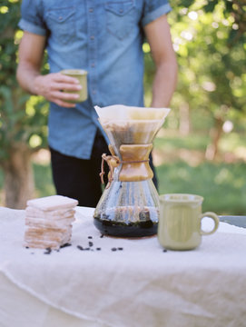 An apple orchard in Utah. man standing at a table, making coffee.