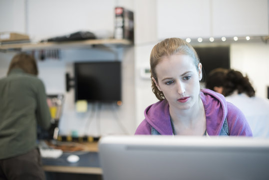 Computer Repair Shop,. A Woman At A Computer Frowning At The Screen. 