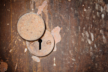 Vintage rust metal keyhole decorative element on weathered woode