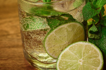 Mojito cocktail with fresh lime on wood table