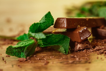 stack of chocolate pieces with a leaf of mint 