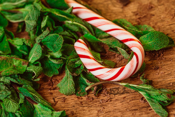 Candy canes with mint leaves  on a wooden background © ruslan1117