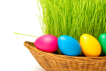 Basket with Easter eggs and grass. Isolated