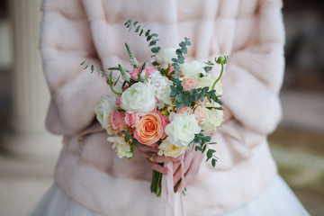 Beautiful wedding bouquet of roses in hands of bride.