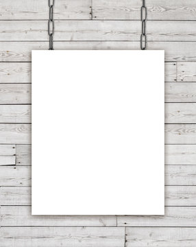 White rectangular poster hanging on chain over wooden background