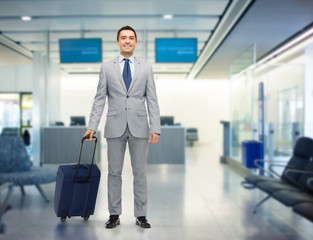 happy businessman in suit with travel bag