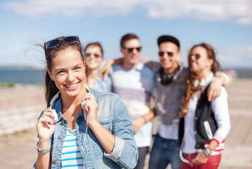 teenage girl with headphones and friends outside