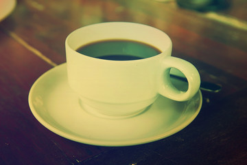 Black coffee in a white cup on the table.