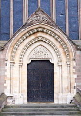 Fototapeta na wymiar Large ornate wood door leads into a Cathedral