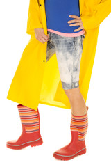 woman legs in yellow coat and rain boots side