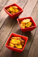 Fried slices of the ripe plantain in small red bowls