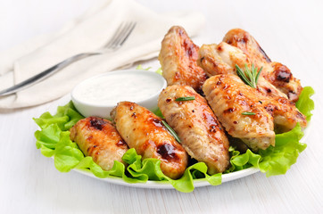 Fried chicken wings on lettuce leaves