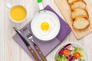 Healthy breakfast with fried egg, toasts and salad