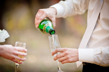 Wedding glasses of champagne in groom's hands