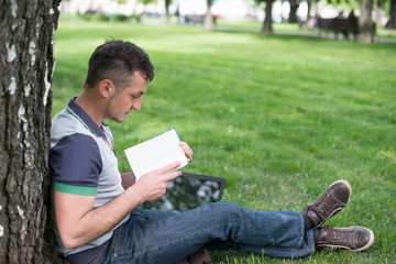 Group of Teenage Students at Park with Computer and Books