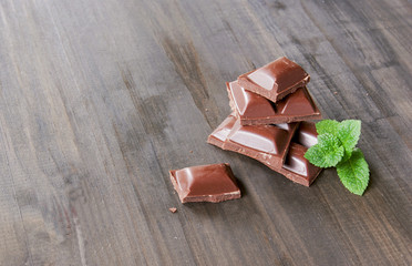 pieces of chocolate with mint lying on a wooden