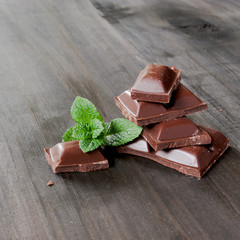 pieces of chocolate with mint lying on a wooden