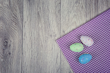 Artificial easter eggs on wooden background in rustic style