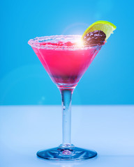 Fruit cocktail on pastel blue background, with sunflare
