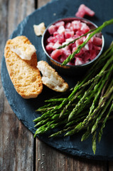 Asparagus with ham on the wooden table, selective focus