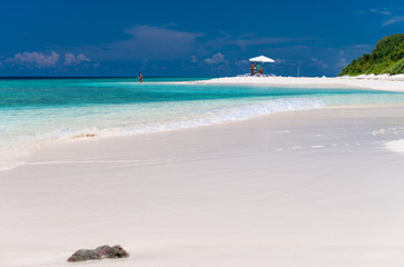 Fototapeta na wymiar Beach umbrella on a white sand