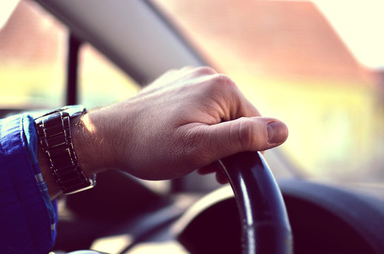 Driver hands holding steering wheel