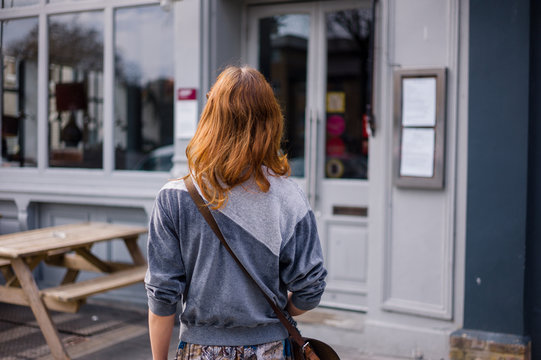 Young woman standing outside pub