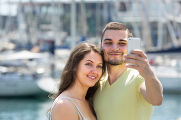 Girl and guy taking selfie in city