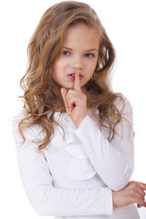Naklejka premium Little girl has put forefinger to lips as sign of silence