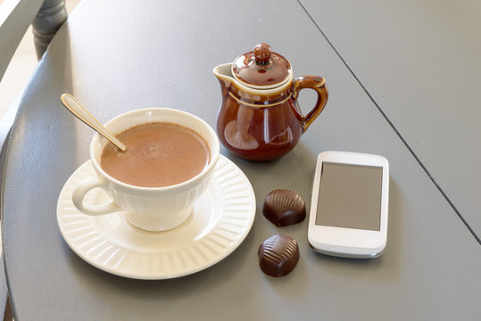 cup of hot chocolate with a phone