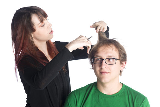 Female hairdresser cutting hair of a male client