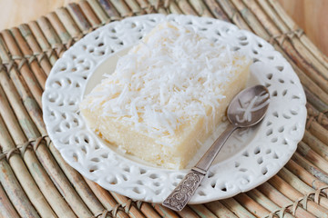 Sweet couscous pudding  with coconut on white plate with spoon