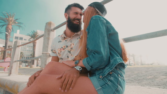 Hipster girlfriend playfully biting her boyfriend's cheek