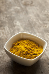 curry spice in wooden bowl