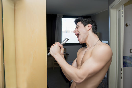 Funny Portrait Of Young Man Singing On Hair Brush