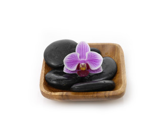 Fototapeta premium pink orchid with black stones on wooden bowl