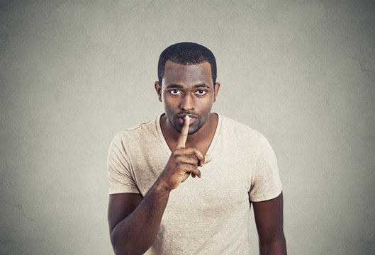 Man with finger on lips gesture keep quiet gray background 