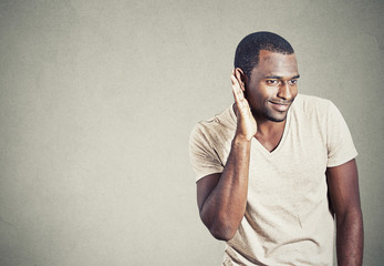 Curious young man eavesdropping listening in on conversation