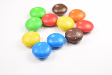 Colorful candies spread on white background.