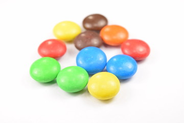 Colorful candies spread on white background.