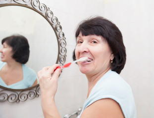 elderly woman brushing her teeth