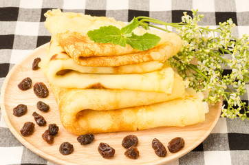 Pancake with raisin on wooden plate
