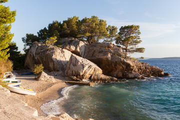 Coast of Croatia. Rocks, boats and pine trees.