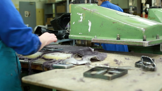 Woman cuts insoles and other details from fur skin